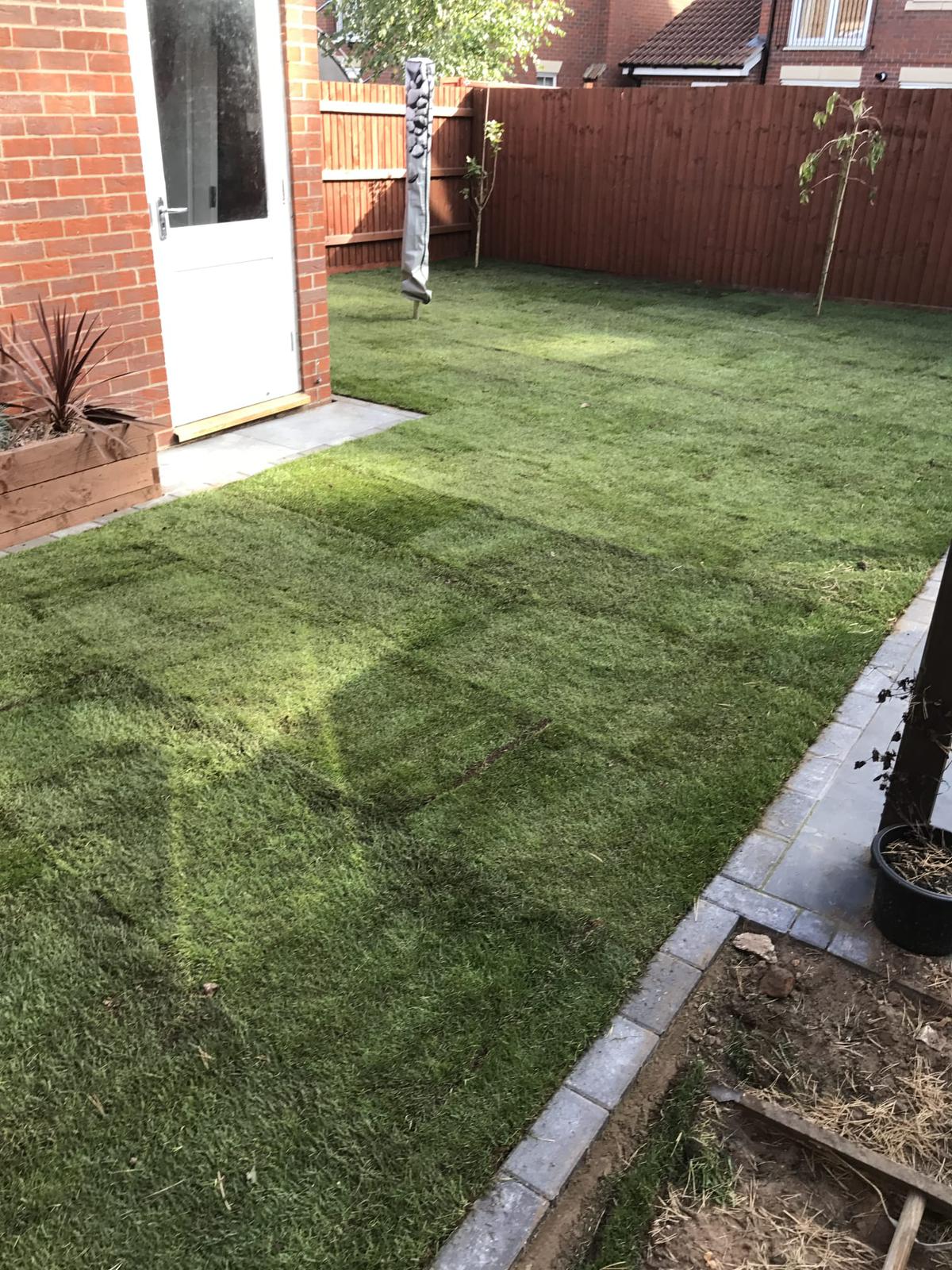 This is a newly turfed garden with a grey brick border.
